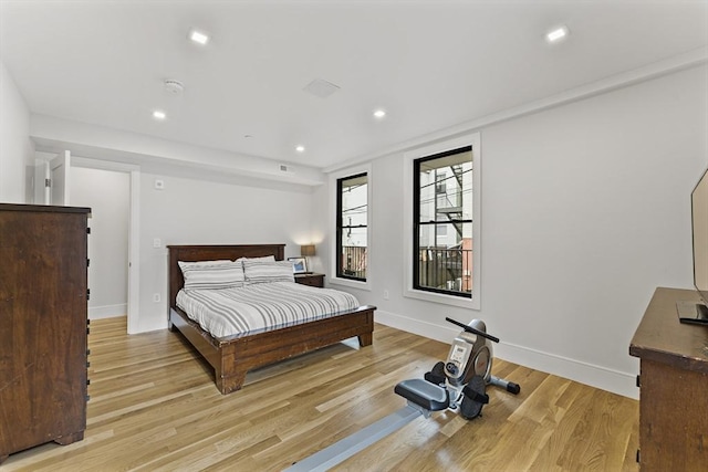 bedroom with light wood finished floors, baseboards, and recessed lighting