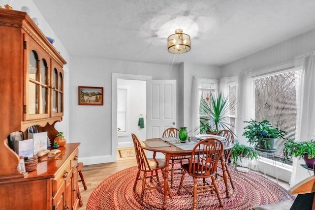 dining room with a notable chandelier and light wood-type flooring