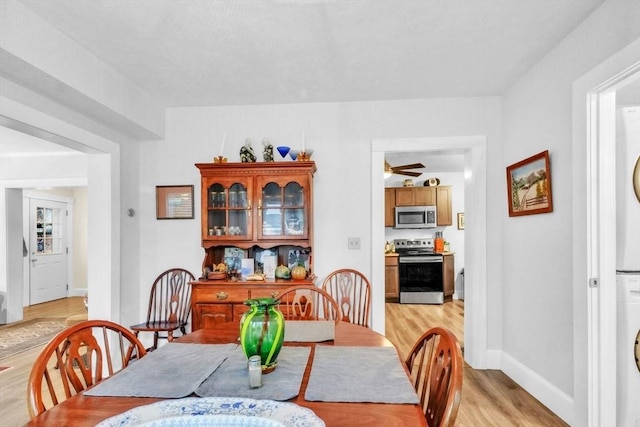 dining area featuring light hardwood / wood-style floors and stacked washer / dryer