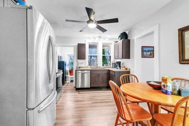 kitchen featuring light wood-type flooring, stainless steel appliances, ceiling fan, and sink