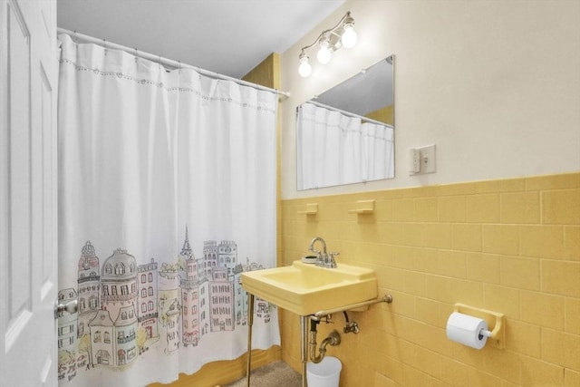 bathroom with sink and tile walls