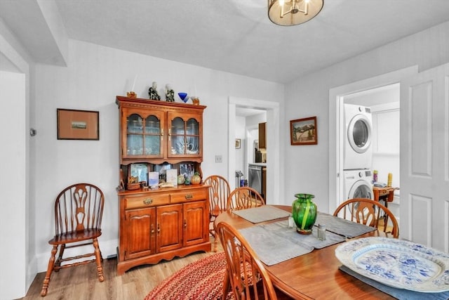 dining room featuring light hardwood / wood-style floors and stacked washer / dryer