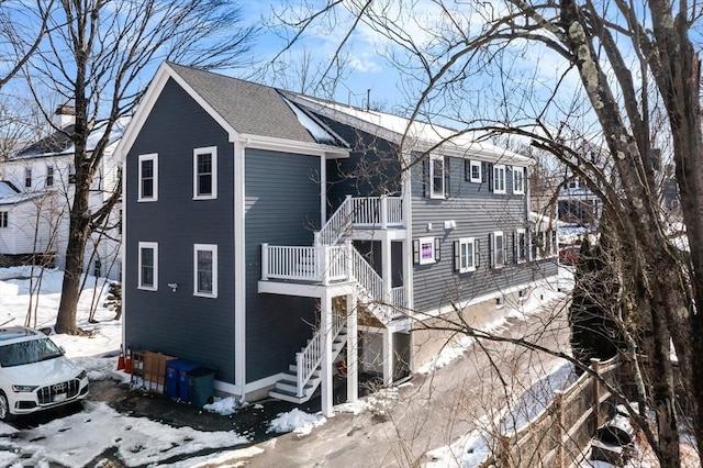 view of front of house with stairs and roof with shingles