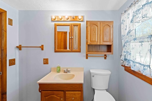 bathroom with toilet and vanity