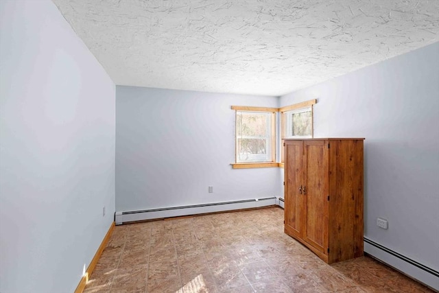 unfurnished room with baseboard heating, a textured ceiling, and tile patterned floors