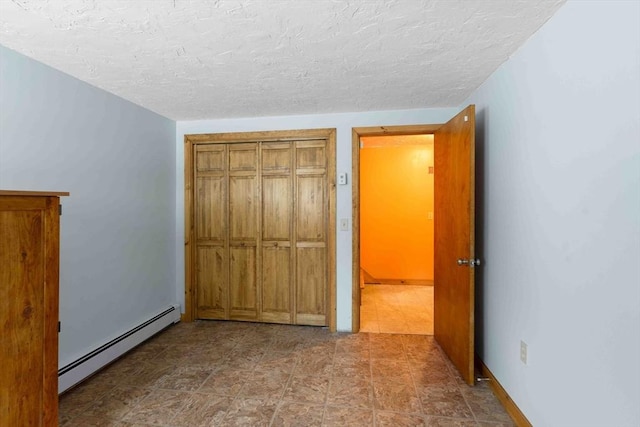 unfurnished bedroom with a textured ceiling and baseboard heating