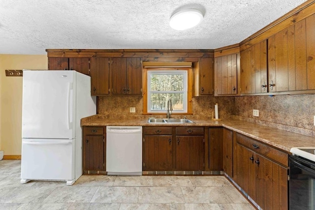 kitchen featuring a textured ceiling, white appliances, a sink, and decorative backsplash