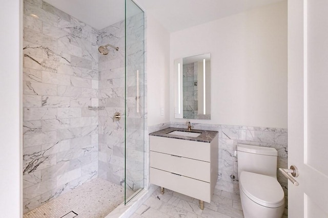 bathroom featuring a tile shower, vanity, toilet, and tile walls