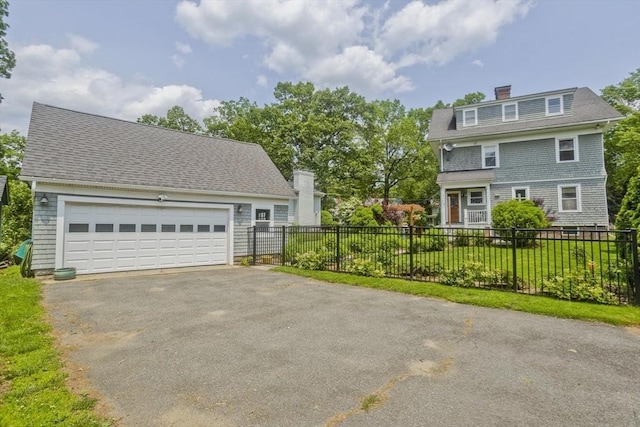 104 Longmeadow St, Longmeadow, MA 01106 - view of front facade with asphalt driveway, a garage, and a chimney