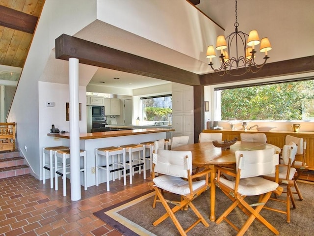 dining space with brick patterned flooring, a chandelier, vaulted ceiling, and baseboards