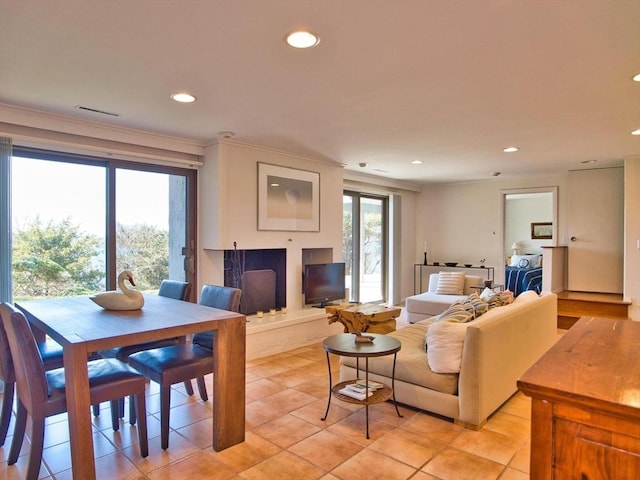 living area with recessed lighting, light tile patterned floors, and ornamental molding