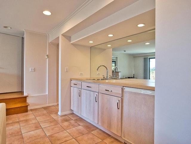 kitchen featuring dishwashing machine, recessed lighting, a sink, light countertops, and light tile patterned floors