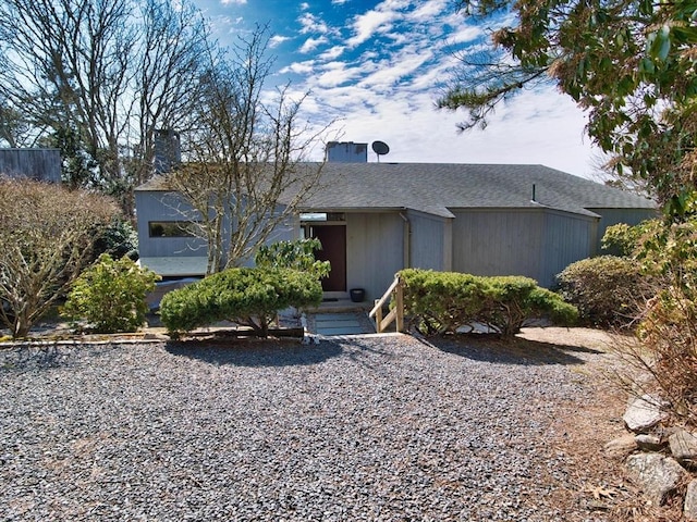 view of front of house with a chimney and a shingled roof