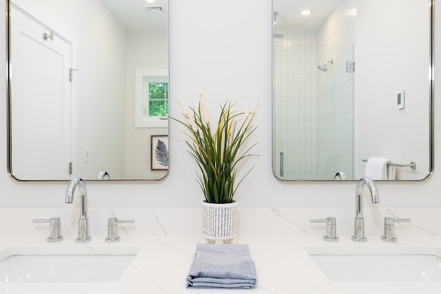 bathroom with walk in shower and dual bowl vanity