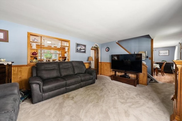 34 Robert Bigelow St, Chelmsford, MA 01824 - carpeted living room with a wainscoted wall, wooden walls, and arched walkways