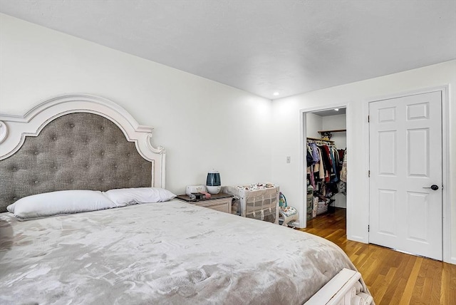 bedroom with hardwood / wood-style flooring, a closet, and a spacious closet