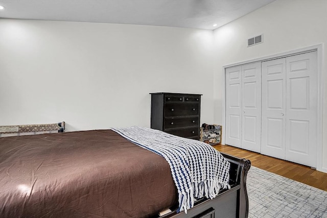 bedroom featuring a closet, hardwood / wood-style flooring, and vaulted ceiling