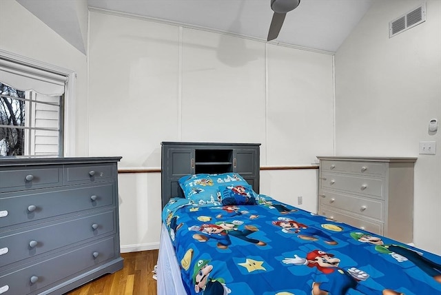 bedroom featuring ceiling fan, light hardwood / wood-style floors, and lofted ceiling