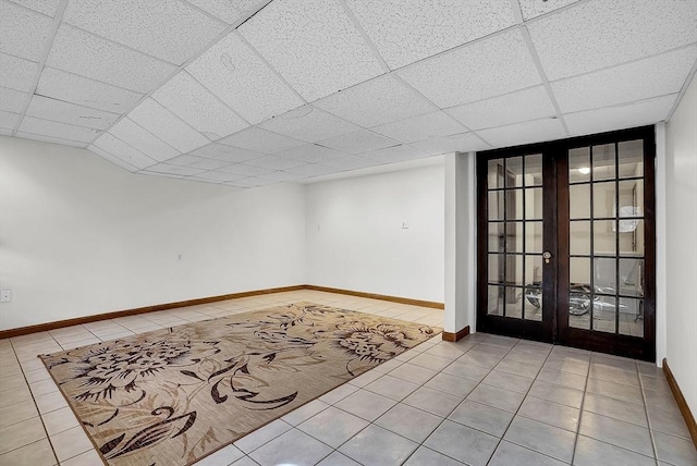 foyer entrance featuring french doors, a paneled ceiling, and light tile patterned floors