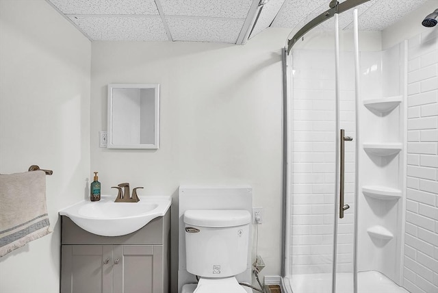 bathroom featuring vanity, a shower with shower door, a paneled ceiling, and toilet