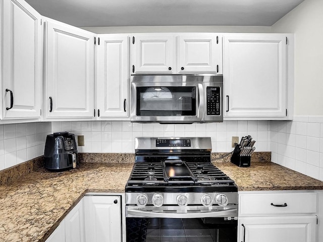 kitchen featuring white cabinets, stainless steel appliances, and tasteful backsplash