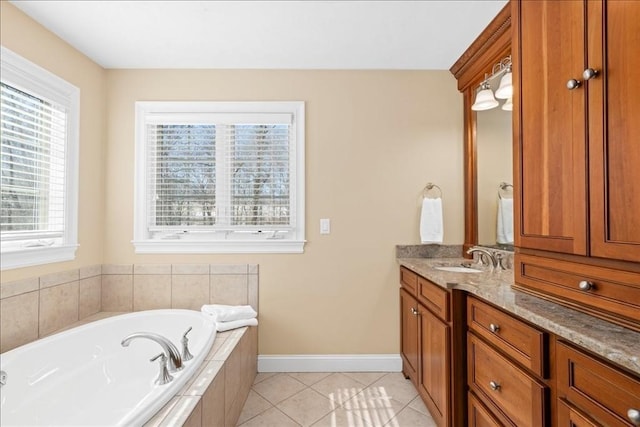 bathroom with a garden tub, tile patterned flooring, baseboards, and vanity