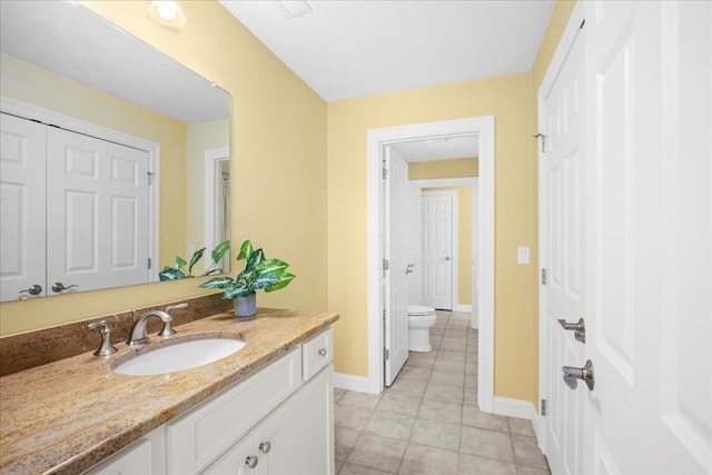 bathroom featuring tile patterned flooring, vanity, toilet, and baseboards