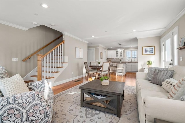 living room featuring light wood-type flooring and crown molding