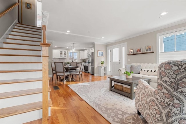 living room featuring ornamental molding and light wood-type flooring