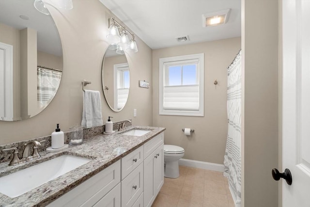 bathroom with vanity, tile patterned flooring, and toilet