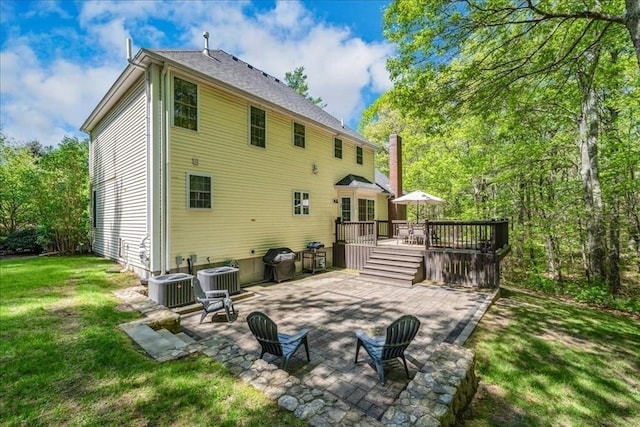 back of property with a patio area, a lawn, a wooden deck, and cooling unit