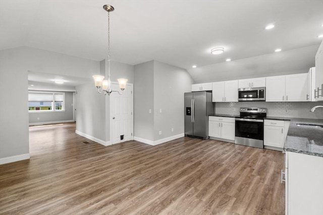42 Deer Hollow Rd, Sandwich, MA 02644 - kitchen featuring appliances with stainless steel finishes, lofted ceiling, open floor plan, a chandelier, and decorative backsplash