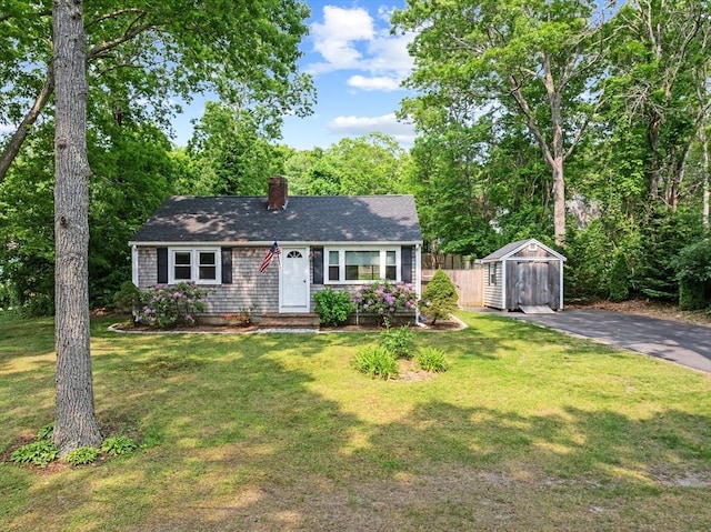 42 Deer Hollow Rd, Sandwich, MA 02644 - view of front facade featuring a storage shed, a chimney, and a shingled roof