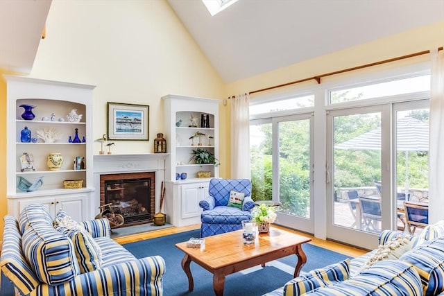86 Champlain, Chatham, MA 02633 - living room featuring high vaulted ceiling, wood finished floors, a brick fireplace, and a skylight
