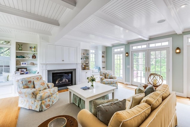 86 Champlain, Chatham, MA 02633 - living area featuring light wood-style flooring, beamed ceiling, a glass covered fireplace, french doors, and built in features