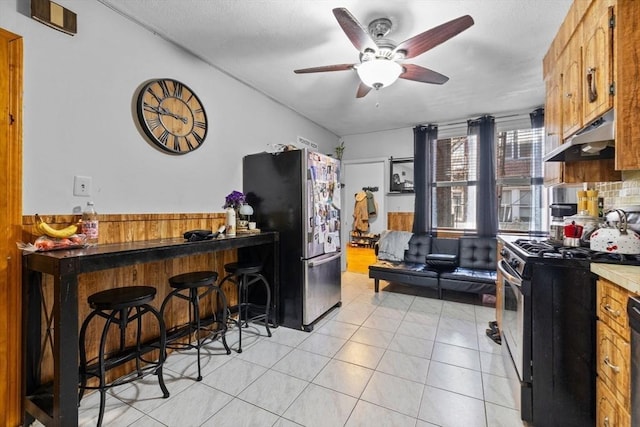 25 Sheafe St, Boston, MA 02113 - kitchen featuring stainless steel appliances, under cabinet range hood, a ceiling fan, wainscoting, and a kitchen breakfast bar