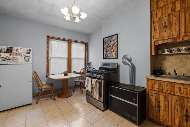 25 Sheafe St, Boston, MA 02113 - kitchen featuring stainless steel gas stove, freestanding refrigerator, brown cabinetry, and a chandelier