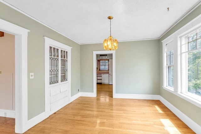 17 Matchett St, Boston, MA 02135 - unfurnished dining area featuring a chandelier, light wood-style flooring, crown molding, and baseboards
