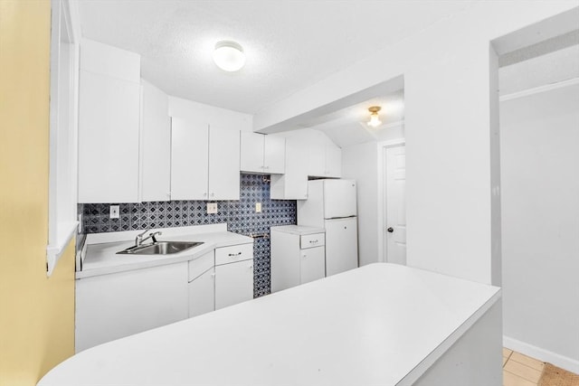 17 Matchett St, Boston, MA 02135 - kitchen featuring freestanding refrigerator, a sink, white cabinets, tasteful backsplash, and light countertops