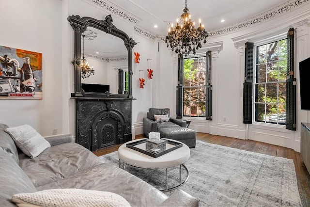 living room with a chandelier, wood-type flooring, a fireplace, and recessed lighting