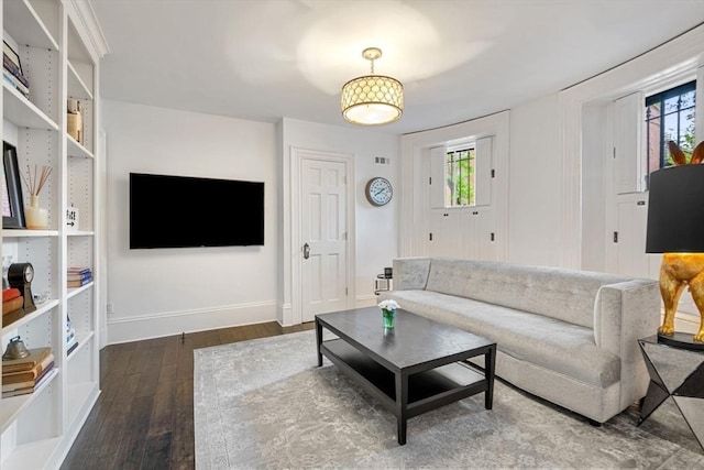 living room with dark wood finished floors, baseboards, and healthy amount of natural light