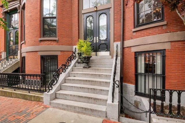 view of exterior entry with french doors and brick siding