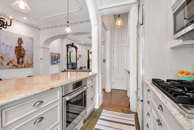 bar with appliances with stainless steel finishes, arched walkways, pendant lighting, and decorative columns