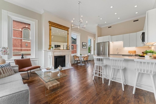 kitchen with white cabinets, stainless steel appliances, dark hardwood / wood-style floors, and crown molding