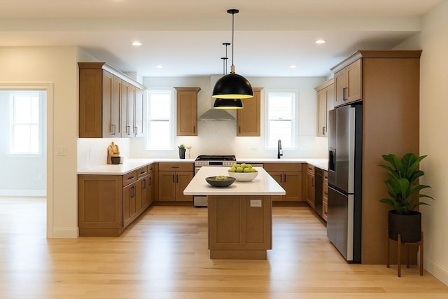 59 Dartmouth St Unit B, Somerville, MA 02145 - kitchen with appliances with stainless steel finishes, wall chimney exhaust hood, light wood-style floors, light countertops, and a kitchen island