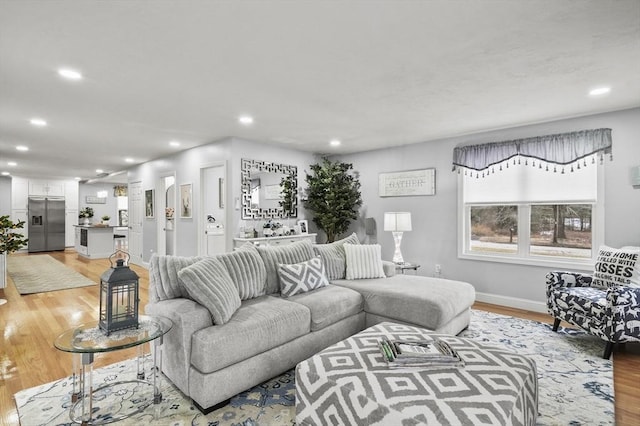 living room with recessed lighting, baseboards, and light wood finished floors