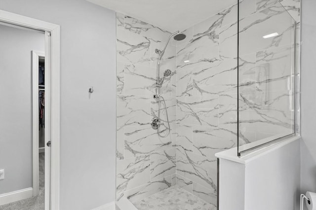 bathroom featuring a marble finish shower