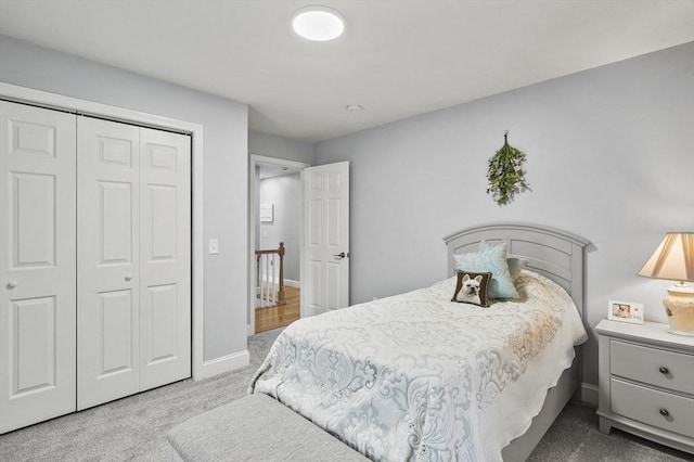 carpeted bedroom with a closet and baseboards