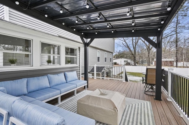 wooden terrace with an outdoor hangout area and fence