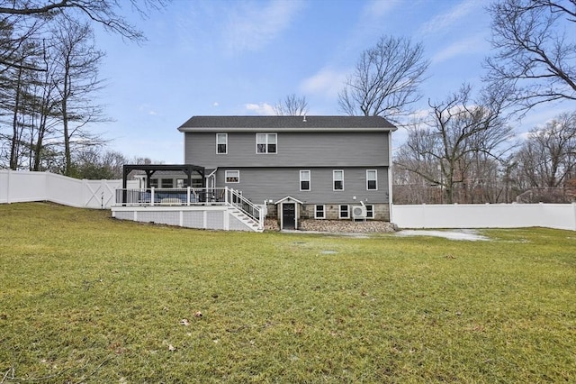 rear view of house with a deck, a lawn, stairway, and a fenced backyard